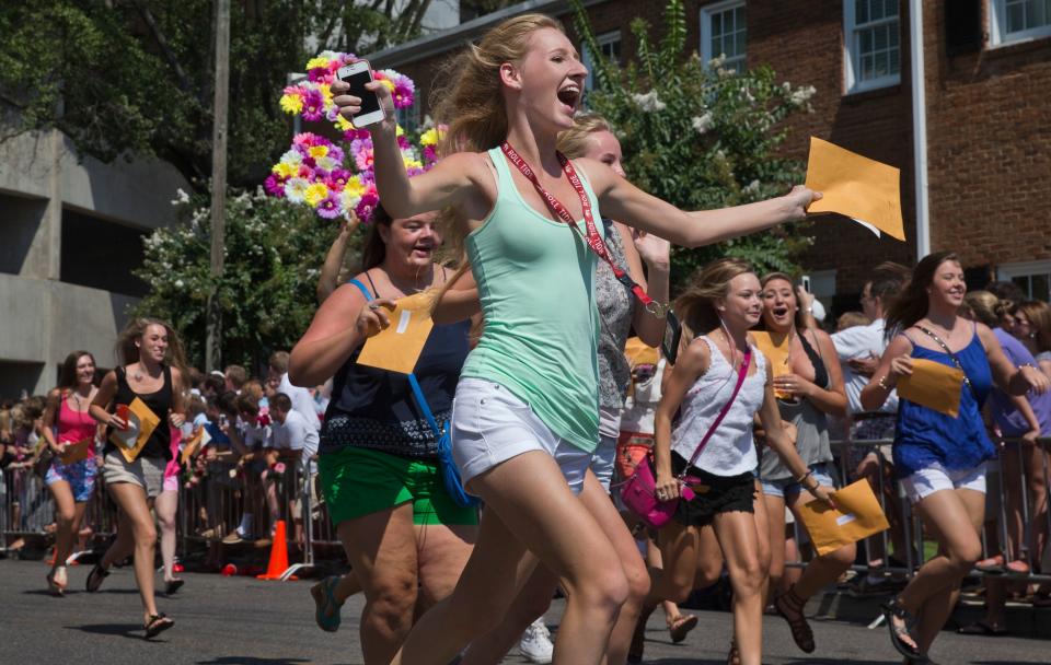 The University of Alabama Delta Gamma's newest sorority members run screaming out of BryantñDenny Stadium with excitement during sorority Bid Day on Saturday, Aug. 16, 2014.