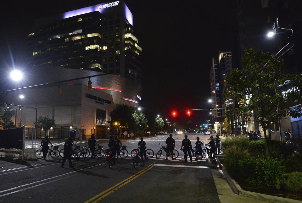 Charlotte Mecklenburg Police bike officers wait at the intersection of Brevard Street and Stonewall Street as demonstrators protest, in uptown Charlotte, N.C., Friday, Aug. 21, 2020. (Jeff Siner/The Charlotte Observer via AP)