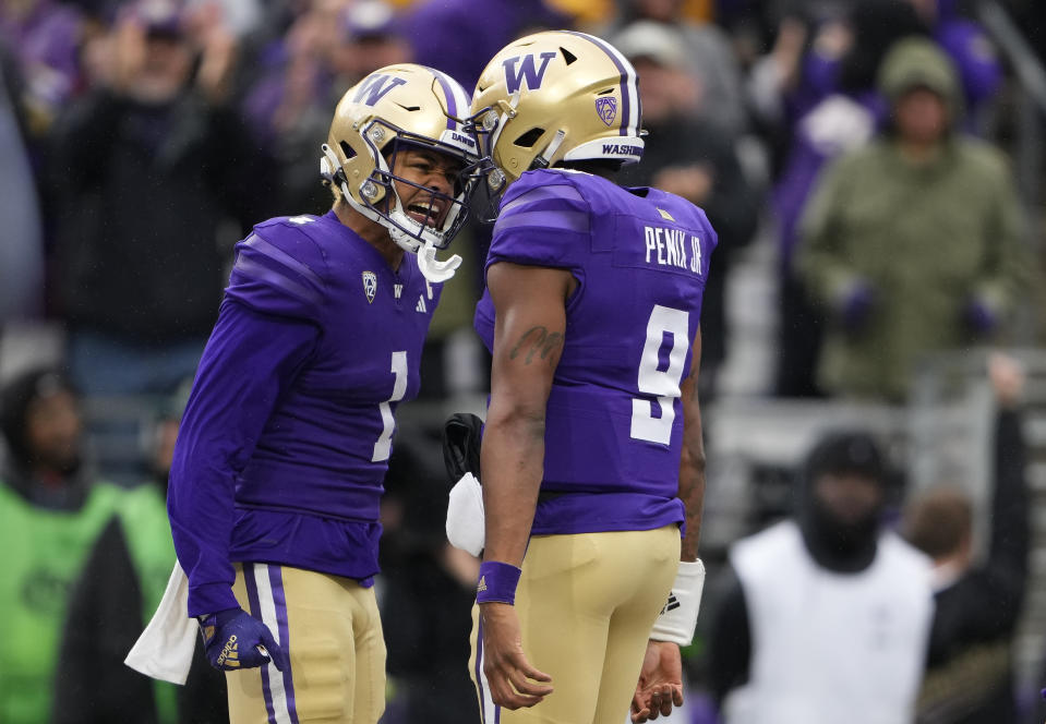 Washington wide receiver Rome Odunze (1) celebrates his touchdown catch with quarterback Michael Penix Jr. (9) against Utah during the second half of an NCAA college football game Saturday, Nov. 11, 2023, in Seattle. Washington won 35-28. (AP Photo/Lindsey Wasson)