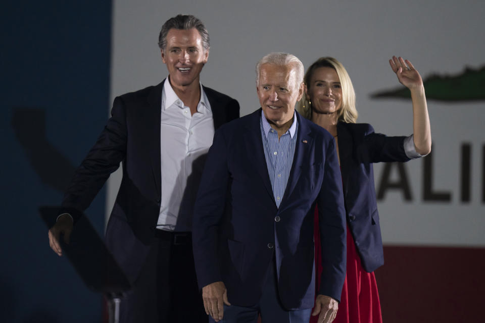 President Joe Biden, center, smiles to the crowd as he is flanked by California Gov. Gavin Newsom, and wife, Jennifer Siebel Newsom, at a rally ahead of the California gubernatorial recall election Monday, Sept. 13, 2021, in Long Beach, Calif. (AP Photo/Jae C. Hong)