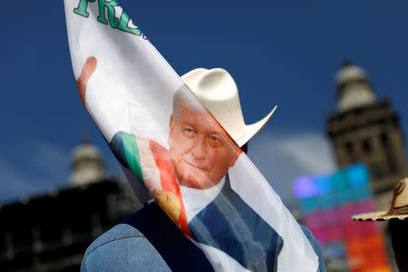 A supporter of Mexico's new President Andres Manuel Lopez Obrador holds a banner while waiting for his arrival at Zocalo square in Mexico City, Mexico December 1, 2018. REUTERS/Edgard Garrido