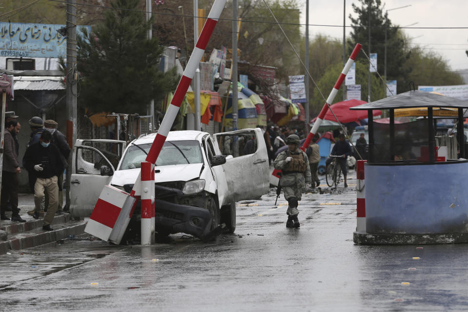 An Afghan security forces member looks at a damaged vehicle after an bomb explosion in Kabul, Afghanistan, Monday, March 30, 2020. A sticky bomb attached to the vehicle detonated, according to Firdaus Faramraz, spokesman for the Kabul police chief. (AP Photo/Rahmat Gul)