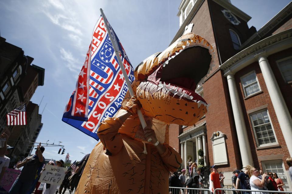 A marcher wears a dinosaur costume during the Straight Pride Parade in Boston, Saturday, Aug. 31, 2019. Several dozen marchers and about as many counter-demonstrators have gathered in Boston for a "straight pride" parade. The organizers say they believe straight people are an oppressed majority. (AP Photo/Michael Dwyer)