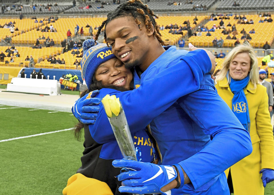 University of Pittsburgh defensive back Damar Hamlin hugs his mother, Nina Hamlin, on senior day before taking on Boston College in an NCAA college football game, Saturday, Nov. 30, 2019, at Heinz Field in Pittsburgh. At rear right is University of Pittsburgh Athletic Director Heather Lyke. Buffalo Bills safety Damar Hamlin is breathing on his own and able to talk after having his breathing tube removed, his agent said Friday, Jan. 6, 2023, the latest step in his remarkable recovery in the four days since going into cardiac arrest and being resuscitated on the field during a game against the Cincinnati Bengals. (Pittsburgh Post-Gazette via AP)