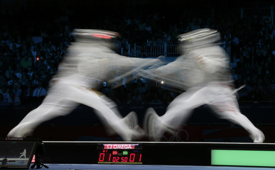 Romania's Rares Dumitrescu, left, competes with Italy's Diego Occhiuzzi during a semifinal in the men's fencing individual sabre at the 2012 Summer Olympics, Sunday, July 29, 2012, in London. (AP Photo/Dmitry Lovetsky)