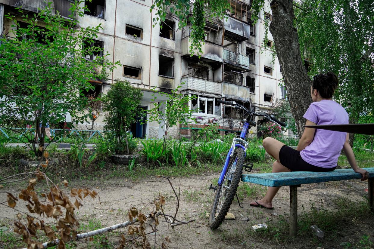 A local woman sits in front of the damaged residential building in Shebekino, Belgorod region, Russia (EPA)