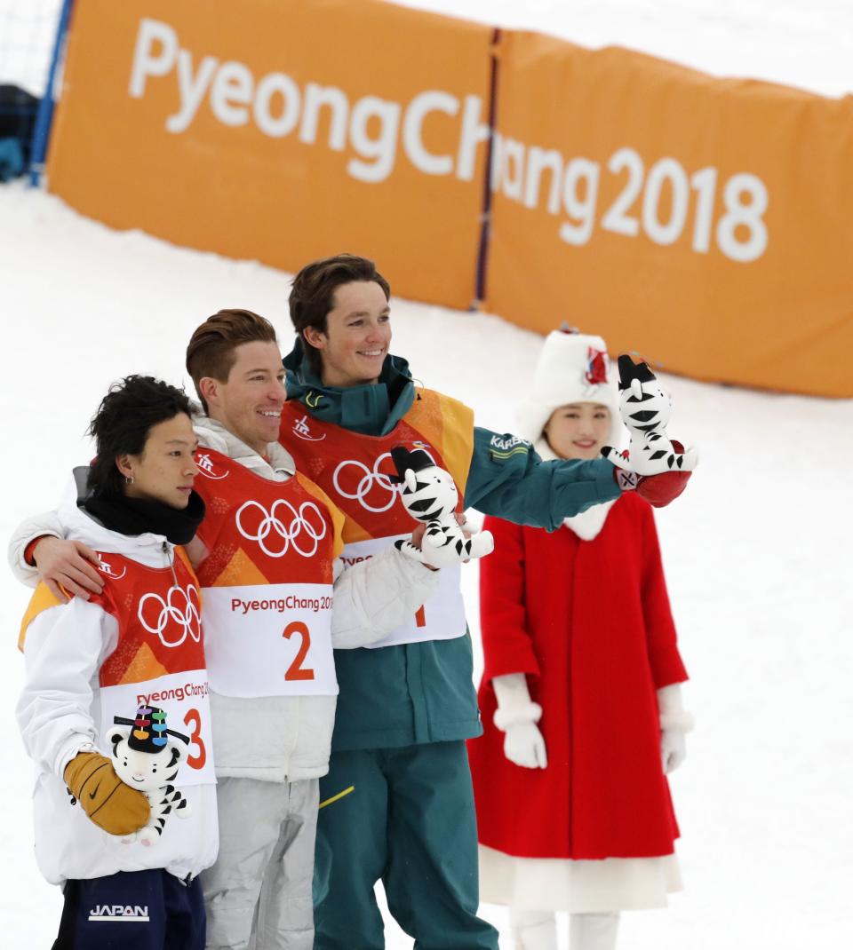 <p>Gold medallist Shaun White of the U.S. flanked by silver medallist Ayumu Hirano of Japan and bronze medallist Scotty James of Australia during the flower ceremony. REUTERS/Jorge Silva </p>