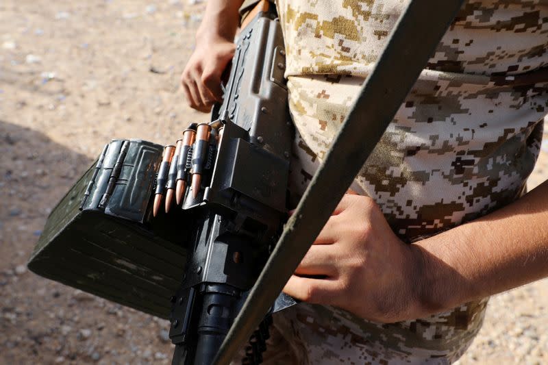 FILE PHOTO: A member of the Libyan internationally recognised government forces carries a weapon in Ain Zara