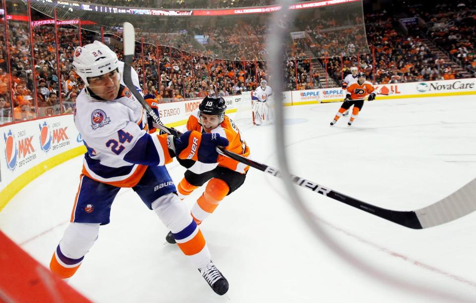 New York Islanders defenseman Steve Staios (24) passes the puck while defended by Philadelphia Flyers center Brayden Schenn (10) in the second period of an NHL hockey game, Thursday, March 1, 2012, in Philadelphia. The Flyers won 6-3.