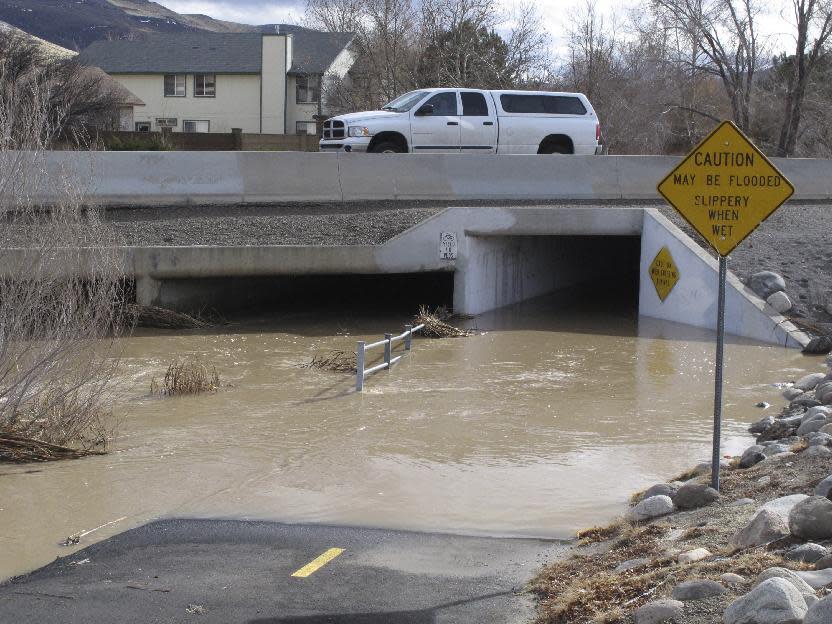 Traffic crosses a bridge over a drainage ditch in Sparks, Nev., Monday, Jan. 9, 2017, where water levels were falling after flooding Sunday night. The worst danger had passed but more rain was in the forecast later this week. (AP Photo/Scott Sonner)