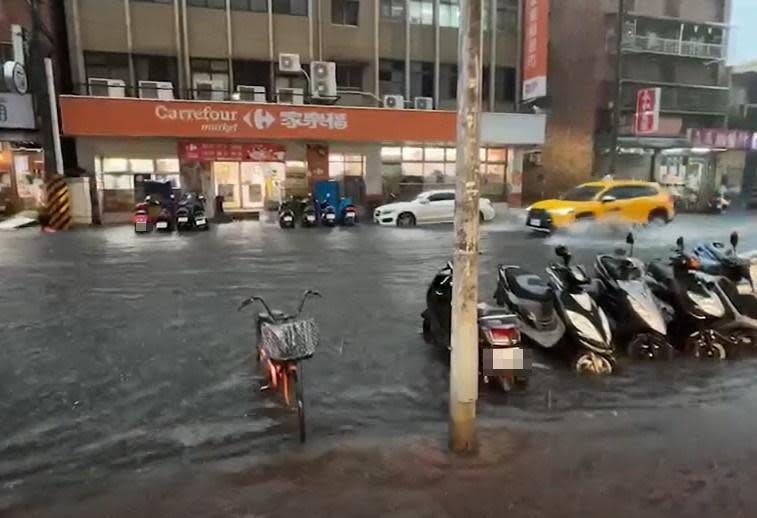 新北三重仁愛街淹水，積水高度已快淹沒路邊機車輪胎。（翻攝自記者爆料網）