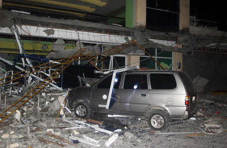 Debris from a building of Surigao State College and Technology is seen on a car after an earthquake hit Surigao city, southern Philippines February 10, 2017. Picture taken February 10, 2017. REUTERS/Roel Catoto-Mindanews