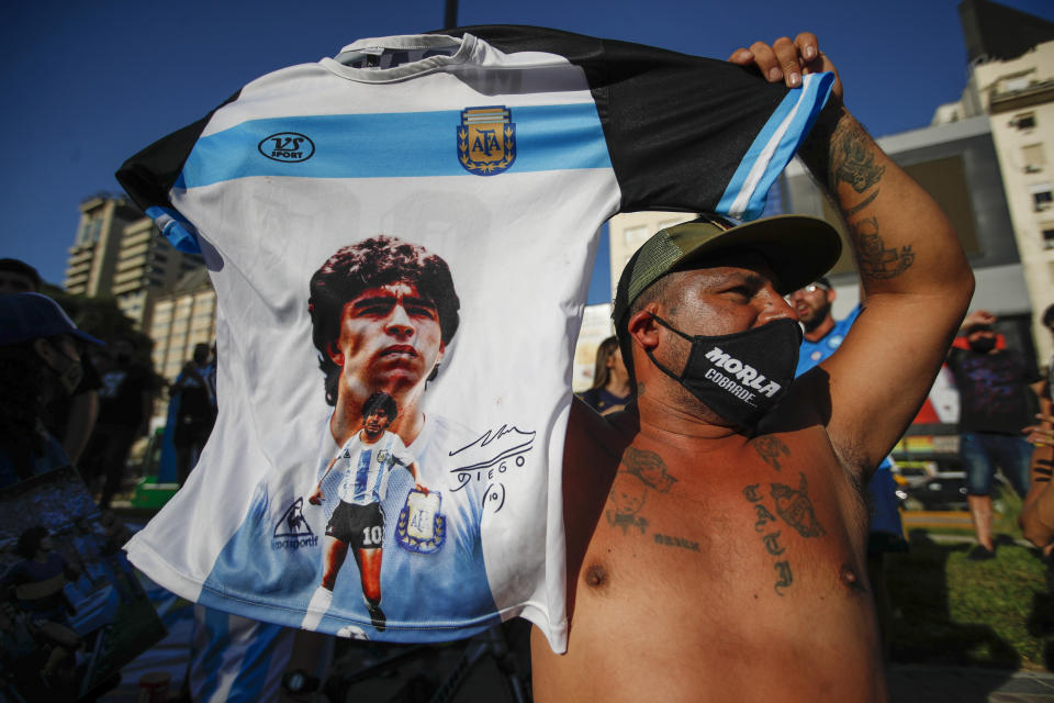 Un individuo alza una camiseta con la imagen del extinto astro del fútbol Diego Maradona durante una marcha para reclamar respuestas por su muerte, en Buenos Aires, el miércoles 10 de marzo de 2021. (AP Foto/Natacha Pisarenko)