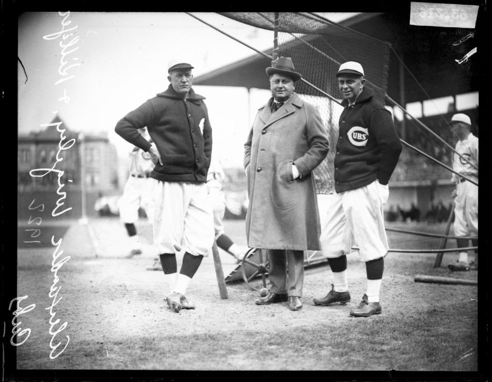 This 1922 photo provided by the Chicago History Museum shows from left, Chicago Cubs baseball player Pete Alexander, team owner William Wrigley Jr., and manager Bill Killefer standing behind a batting practice backstop on the field at Weeghman Park, in Chicago. Weeghman Park was renamed Wrigley Field in 1927. The famed ballpark will celebrate it's 100th anniversary on April 23, 2014. (AP Photo/Courtesy of the Chicago History Museum)