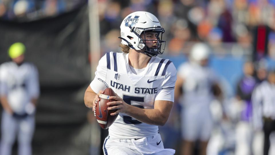 Utah State quarterback Cooper Legas (5) looks downfield against Boise State in the first half of an NCAA college football game, Friday, Nov. 25, 2022, in Boise, Idaho. Boise State won 42-23. | Steve Conner, AP