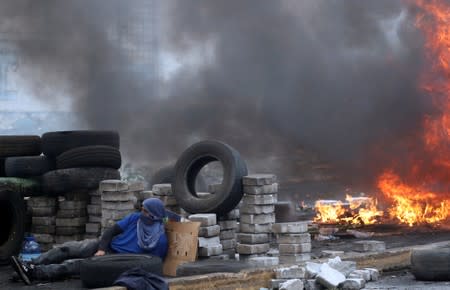 Un manifestante se pone a cubierto durante una protesta contra las medidas de austeridad del presidente de Ecuador, Lenín Moreno, en Quito, Ecuador.