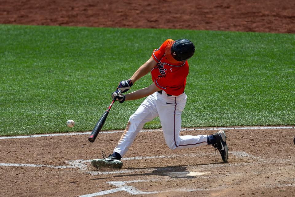 Kyle Teel progressed to the first round of the 2023 draft through his performance at the University of Virginia, shown here delivering a single at a College World Series.
