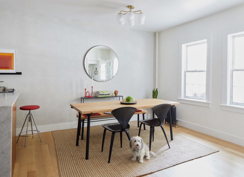 The wood dining table has a fun sculptural element with the powder-coated steel legs. Similarly, the dining chairs, designed by Norman Cherner, are unobtrusive but still have a dramatic sculptural beauty.