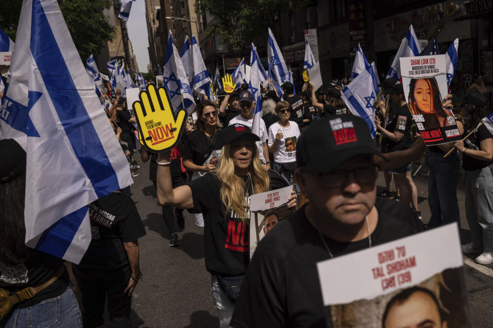 People hold signs and Israeli flags ahead of the annual Israel Day Parade on Sunday, June 2, 2024, in New York. (AP Photo/Yuki Iwamura)