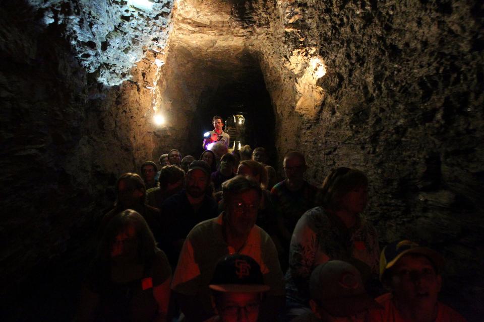 Tour guide Kyle Burkwit leads a group on the boat section during a tour of the Lockport Caves in Lockport, N.Y., on Aug. 21, 2014.