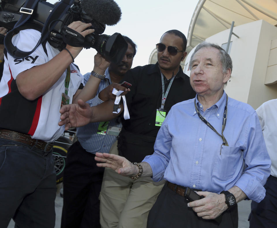 FIA president Jean Todt is embraced by a Ferrari gesticulates with reporters upon his arrival in the paddock after the third practice session at the Formula One Bahrain International Circuit in Sakhir, Bahrain, Saturday, April 5, 2014. The Bahrain Formula One Grand Prix will take place here on Sunday. (AP Photo/Luca Bruno)