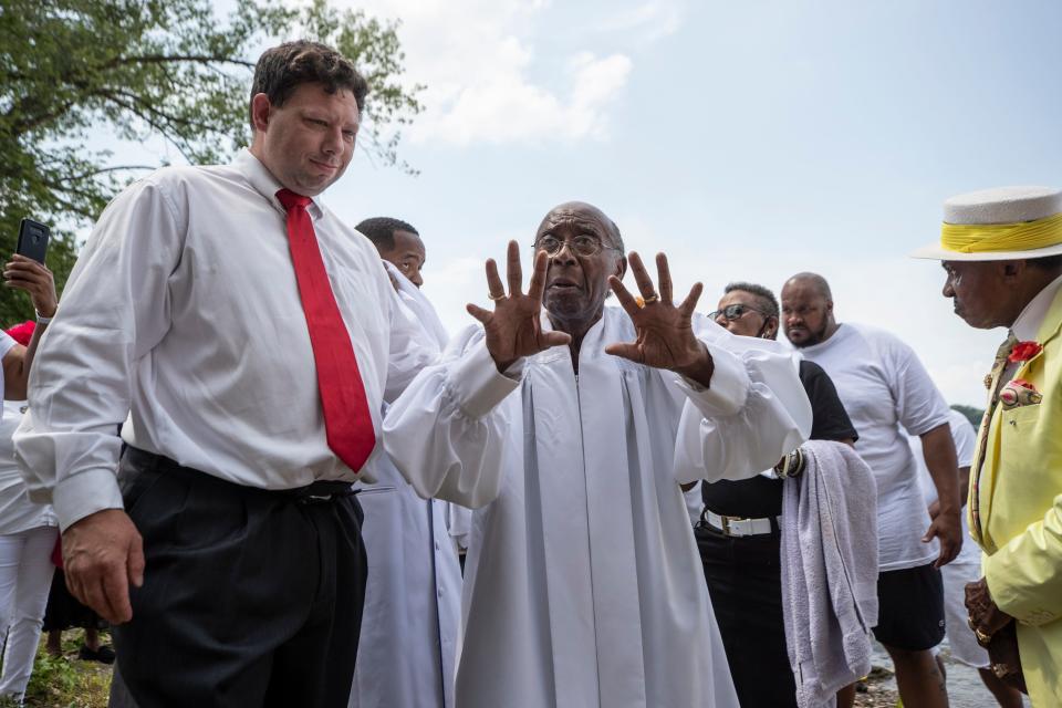 Rev. Charles Elliott, center, thanks Anthony Oxendine, left, for his service to help the community during the surge in gun violence in Louisville. Oxendine is the owner of Spring Valley Funeral Homes and buries many of the poor and indigent each year in the city. Aug. 8, 2021