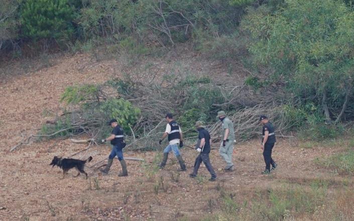 Police lead dogs across the recently cleared ground - Yui Mok/PA Wire