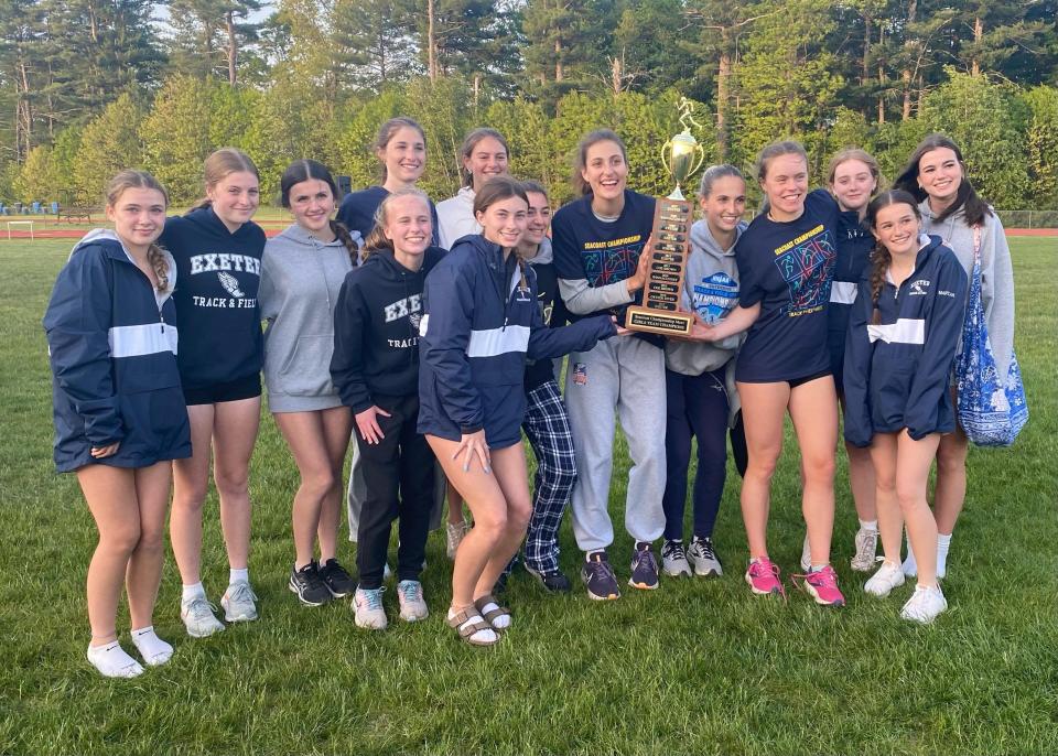 Members of the Exeter High School girl track team celebrate their fifth straight Seacoast Championship Friday night. It also was the 10th Seacoast title in program history.