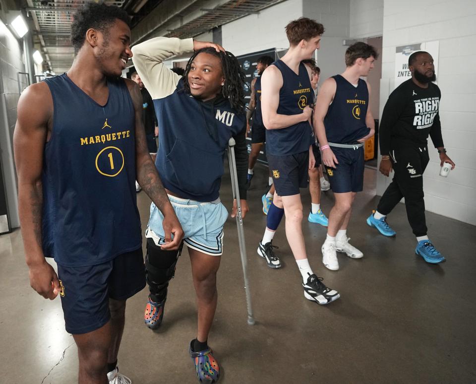 Sean Jones, shown joking around with teammate Kam Jones, has remained an engaged presence on the Marquette team despite his injury.