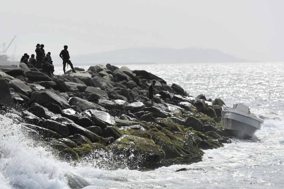 FILE - In this May 3, 2020 file photo, security forces guard the shore area and a boat in which authorities claim a group of armed men landed in the port city of La Guaira, Venezuela. Interior Minister Nestor Reverol said on state television that security forces overcame before dawn Sunday an armed maritime incursion with speedboats from neighboring Colombia in which several attackers were killed and others detained. (AP Photo/Matias Delacroix, File)