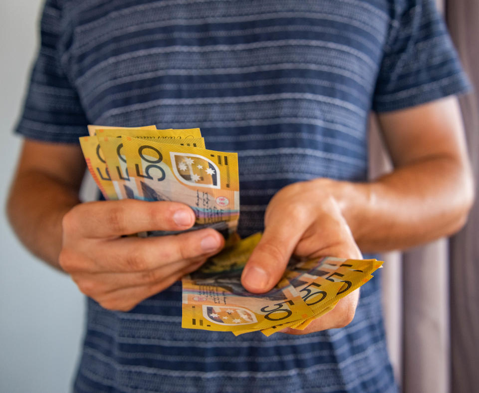 Man handling fifty dollar notes finance. 