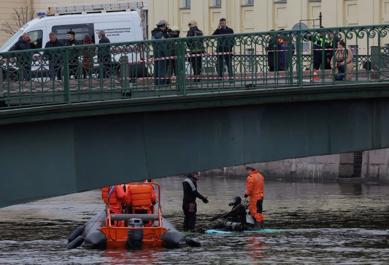 Rescuers work at the site where a bus fell into a river in Saint Petersburg