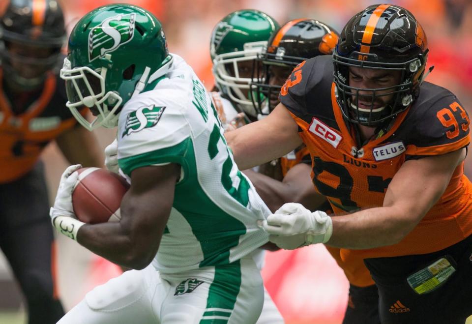 Saskatchewan Roughrider Greg Morris, left, carries the ball past B.C. Lion Craig Roh during the first half of a CFL football game in Vancouver on Saturday August 5, 2017.