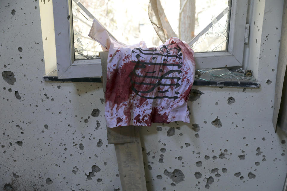 FILE - In this Nov. 3, 2020 file photo, a blood-stained Taliban flag is seen on a window inside the Kabul University after a deadly attack, in Kabul, Afghanistan. In a report released Monday, Feb. 1, 2021, the Special Inspector General for Afghanistan Reconstruction, known as SIGAR, that monitors the billions of dollars the U.S. spends in Afghanistan, said that Taliban attacks in the Afghan capital Kabul are on the rise, with increasing targeted killings of government officials, civil-society leaders and journalists. (AP Photo/Rahmat Gul, File)