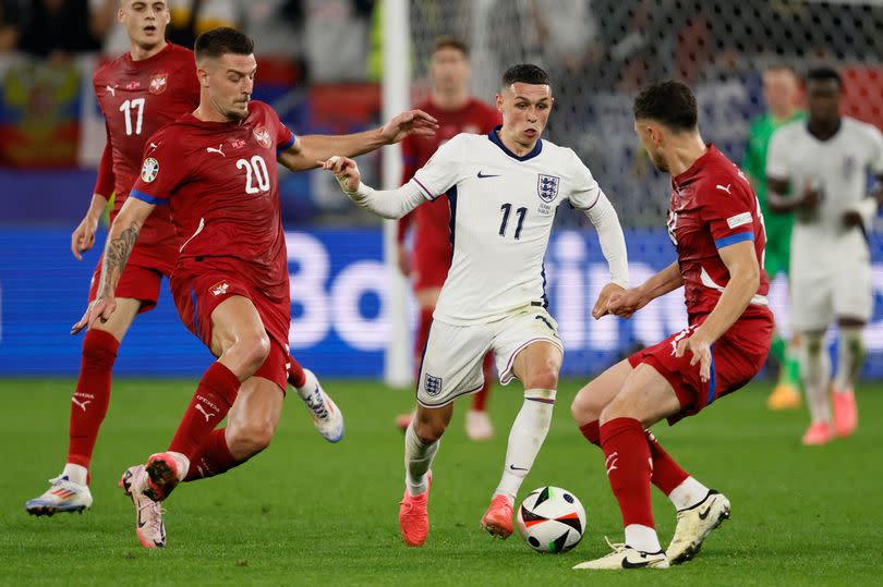 Sergej Milinkovic-Savic of Serbia and Phil Foden of England on the ball after the UEFA EURO 2024 group stage match between Serbia and England at Arena AufSchalke on June 16, 2024 in Gelsenkirchen, Germany.