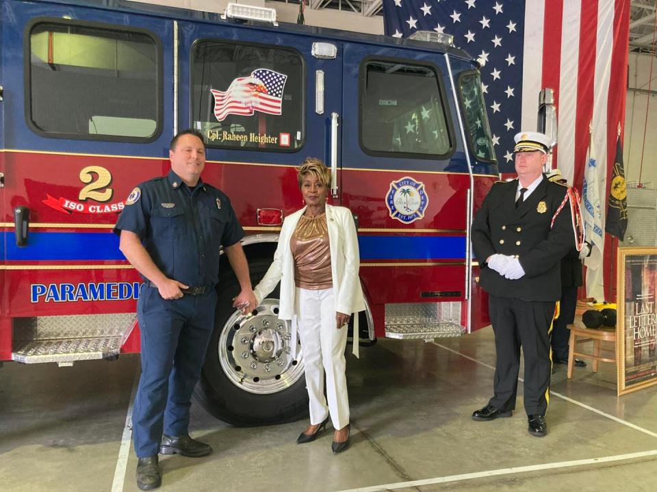 Palm Coast City Council member Cathy Heighter with firefighter paramedic Christopher Strozier (left) and volunteer Battalion Chief Tim Wilsey at a Gold Star dedication ceremony for her son, Raheen Heighter, whose name was inscribed on the window of the fire engine.