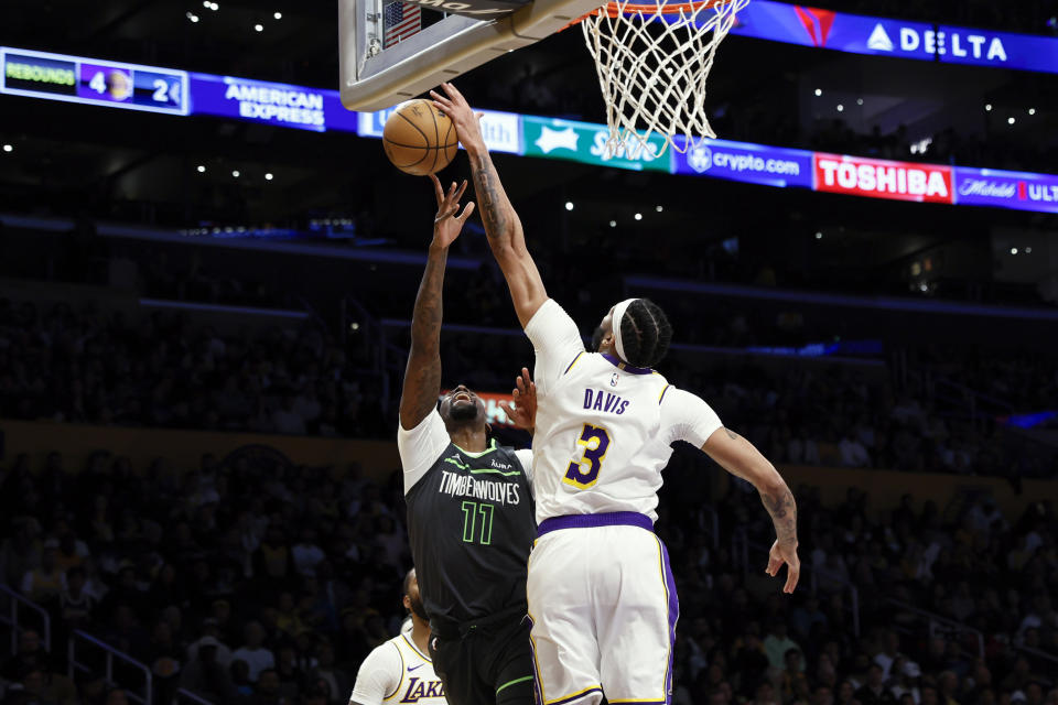Los Angeles Lakers forward-center Anthony Davis (3) commits a foul while defending against Minnesota Timberwolves center-forward Naz Reid (11) during the first half of an NBA basketball game, Sunday, April 7, 2024, in Los Angeles. (AP Photo/Etienne Laurent)