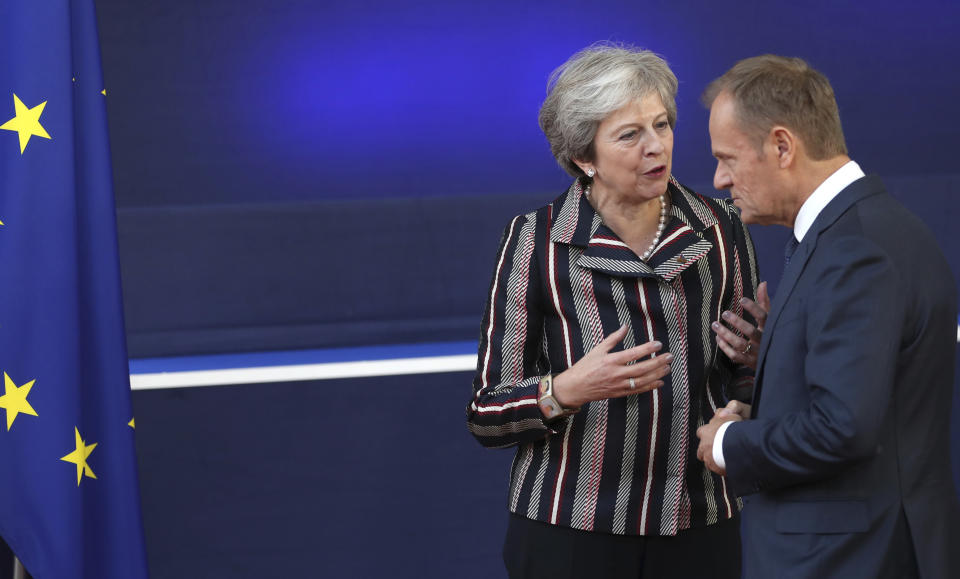 British Prime Minister Theresa May, left, speaks with European Council President Donald Tusk after a group photo during an EU-ASEM summit in Brussels, Friday, Oct. 19, 2018. EU leaders met with their Asian counterparts Friday to discuss trade, among other issues. (AP Photo/Francisco Seco)