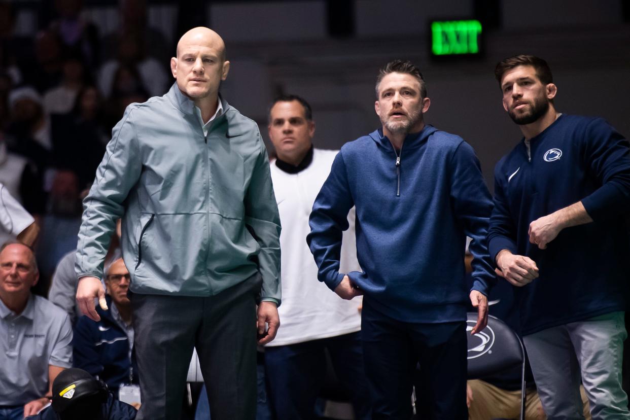 (From left) Penn State wrestling head coach Cael Sanderson, associate head coach Cody Sanderson and assistant coach Jimmy Kennedy react during a dual meet against Ohio State on Feb. 2, 2024, in State College, Pa. The Nittany Lions won, 28-9.