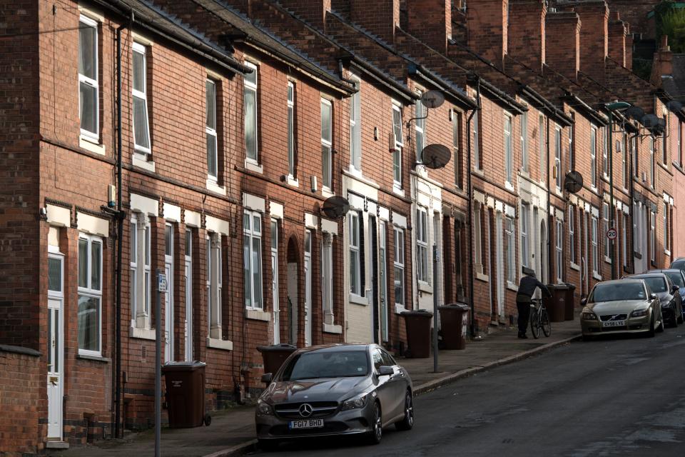 A man pushes a bike up a steep residential street in Nottingham, central England on November 17, 2017. Shoppers at Nottingham's Christmas market complained about higher prices and volunteers handed out food parcels just a few streets away, even as retailers sought to dispel Brexit gloom with Black Friday sales. Britain is gripped by a cost of living crisis sparked in part by the nosedive in the value of the pound after the country voted for Brexit in June 2016, pushing up the price of imported foodstuffs. / AFP PHOTO / OLI SCARFF / TO GO WITH AFP STORY by Kenza BRYAN        (Photo credit should read OLI SCARFF/AFP via Getty Images)