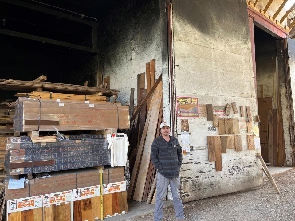 Nick McNutt of Woodstream Hardwoods and Building Specialties is shown on March 21, 2023, next to one of his Division Street business’ giant doors leading to where stacks of a wide variety of hardwoods are stored.