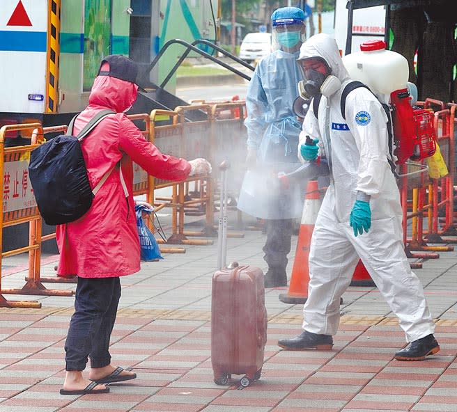 台北市機動快篩隊7日前往台北市萬華熱區執行篩檢，由於若受檢者快篩結果為陽性，將馬上被載往集中檢疫所，等待PCR結果。有民眾預防萬一，拖著行李箱來快篩，結果是陰性鬆了一口氣，離去時特別請化學兵替她全身消毒。（圖文：黃世麒）