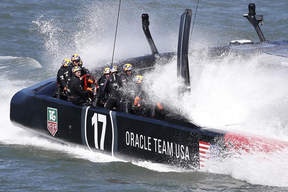 Oracle Team USA crosses finish line ahead of Emirates Team New Zealandduring Race 18 of the 34th America's Cup yacht sailing race in San Francisco