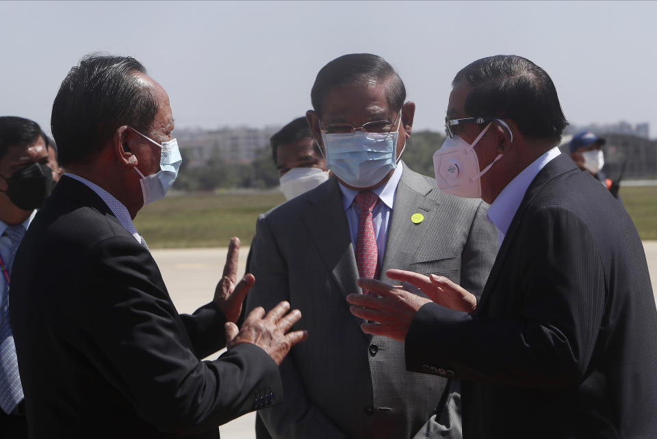 CORRECTS TITLE OF MINISTERS - Cambodian Prime Minister Hun Sen, right, talks with his Deputy Prime Ministers, Sar Kheng, center, also Minister of Interior Ministry, and Tea Banh, left, also Defense Minister, during the arrival at Phnom Penh International Airport from Myanmar, in Phnom Penh, Cambodia, Saturday, Jan. 8, 2022. Cambodian Prime Minister Hun Sen's visit to Myanmar seeking to revive peace efforts after last year's military takeover has provoked an angry backlash among critics, who say he is legitimizing the army's seizure of power. (AP Photo/Heng Sinith)