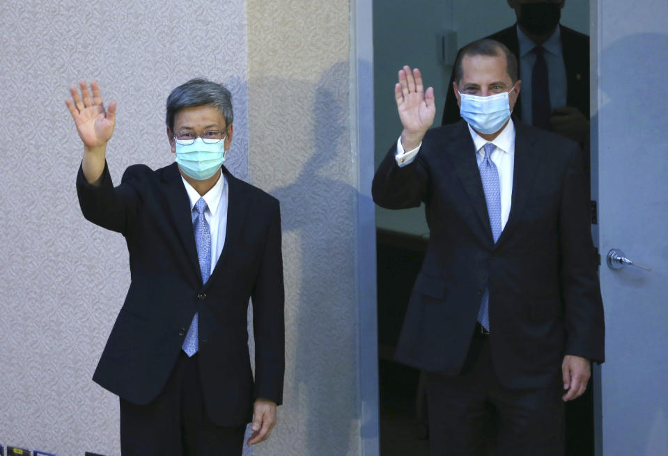 U.S. Health and Human Services Secretary Alex Azar, right, and Taiwan former Vice President Chen Chien-jen wave before Azar delivering speech at National Taiwan University College of Public Health in Taipei, Taiwan Tuesday, Aug. 11, 2020. Azar arrived in Taiwan on Sunday in the highest-level visit by an American Cabinet official since the break in formal diplomatic relations between Washington and Taipei in 1979. (AP Photo/Chiang Ying-ying)