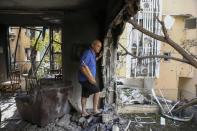 A member of Sror family inspect the damage of their apartment after being hit by a rocket fired from the Gaza Strip over night, in Petah Tikva, central Israel, Thursday, May 13, 2021. (AP Photo/Oded Balilty)