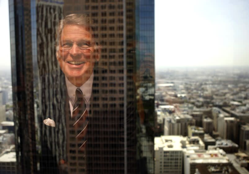 Nelson C. Rising, President and CEO of Maguire Properties, is reflected in a window in the company's offices