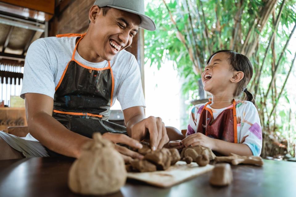 pottery workshop a potter craftsman shows his child how to work with clay