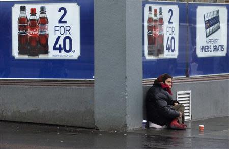 A woman begs for money outside a shop in downtown Bergen, southwestern Norway, in this March 21, 2012 file photo. REUTERS/Stoyan Nenov/Files