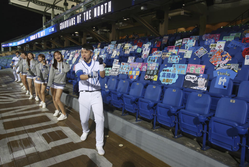 Cheerleaders encourage on the Stadium stands with no audience at Xinzhuang Baseball Stadium in New Taipei City, Taiwan, Friday, April 24, 2020. Taiwan's five-team Chinese Professional Baseball League is barring spectators over concerns they would spread the deadly coronavirus, meaning games are played with plastic seats void of fans.(AP Photo/Chiang Ying-ying)